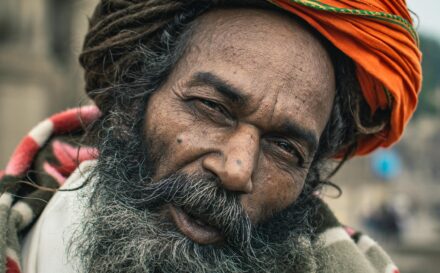 Close-up of an elderly man with colorful turban and beard in Varanasi, India.